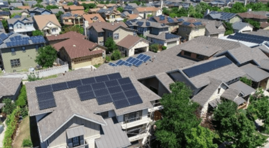 Aerial view of residential neighborhood with solar panels on multiple homes